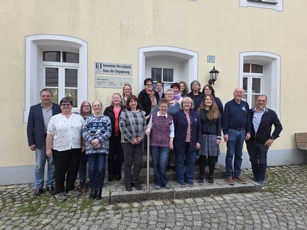 Bild vergr&ouml;&szlig;ern: Gruppenfoto der ehrenamtlichen Bibliothekaren und Bibliothekarinnen des Landkreises Amberg-Sulzbach vor dem Haus der Begegnung in Hirschbach